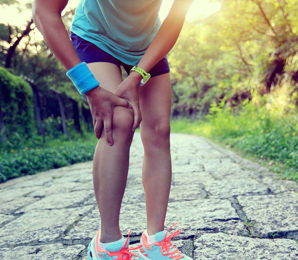 woman holding knee in pain