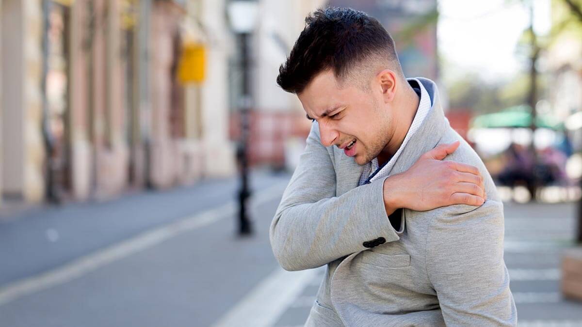 Man holding shoulder and neck in pain