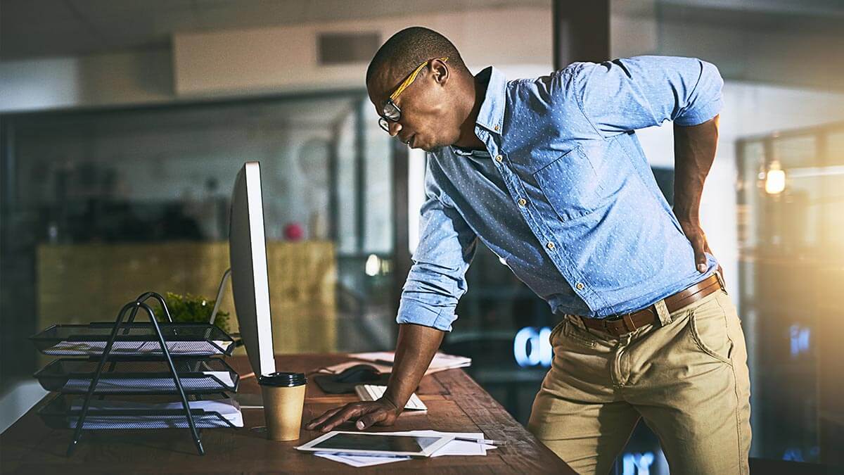 man leaning over holding back in pain